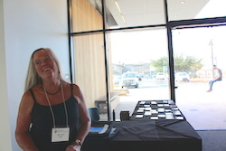 a woman stands in front of a table filled with nametags